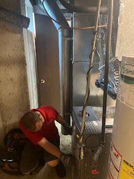 Technician repairing furnace system in basement in Berkeley, MO.